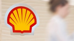 Shell logo with employee climbing steps in the background