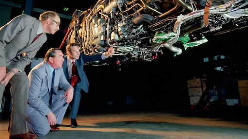 Three men are checking jet engine