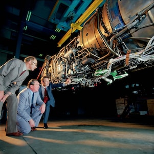 Three men are checking jet engine