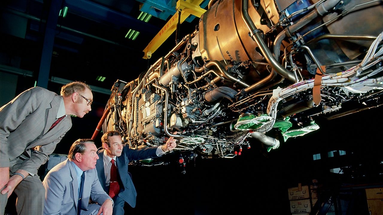 Three men are checking jet engine