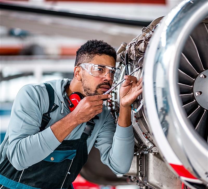 Aviation mechanic inspecting an airplane jet engine