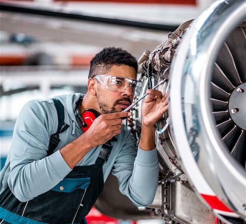 Aviation mechanic inspecting an airplane jet engine