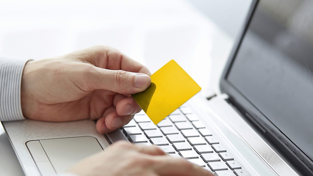 Man with the card on the laptop