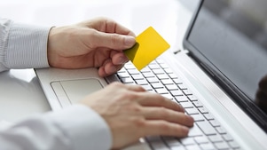 Male hands holding credit card when paying on your notebook