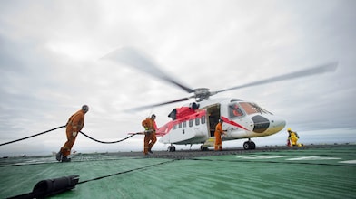 3 individuals working together to fuel a helicopter