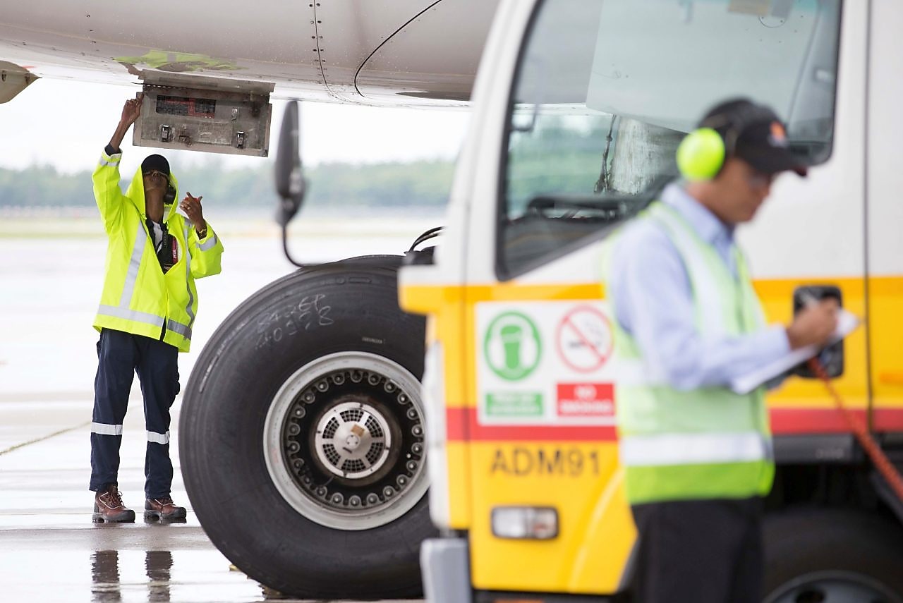 Two men in action while working together to fuel an aircraft