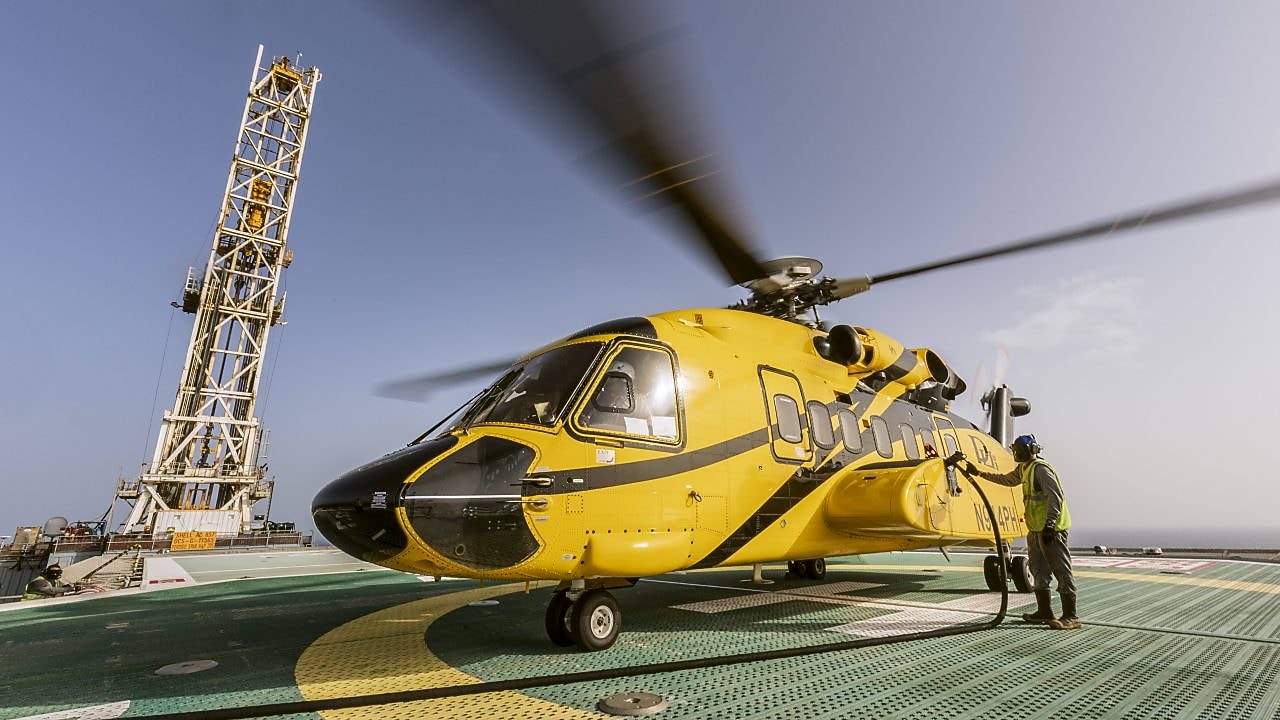 Man servicing helicopter on helipad