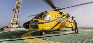 A helicopter that is parked on top of a helipad while being refueled