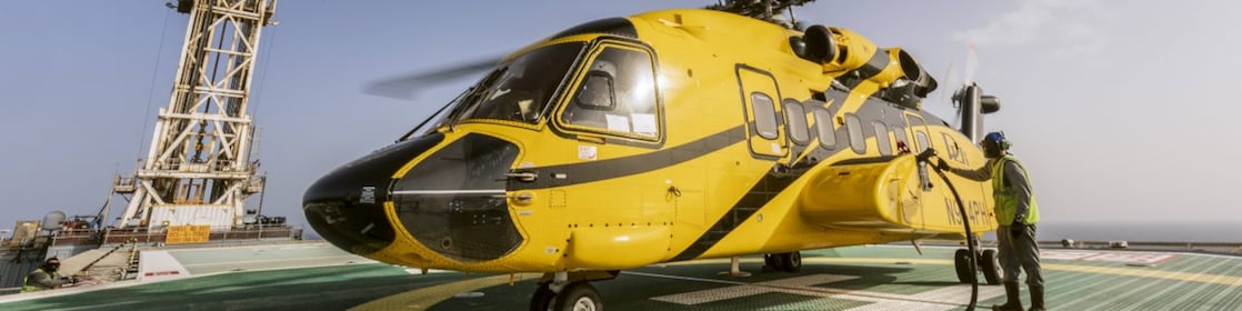 A helicopter that is parked on top of a helipad while being refueled