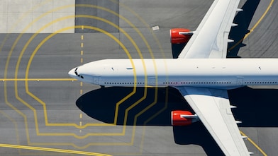 Aerial view of a plane on a runway overlayed with the Shell Pecten