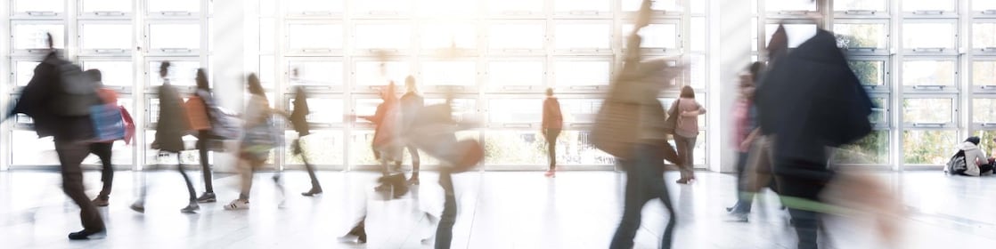A busy airport terminal with people moving fast and blurring out of focus