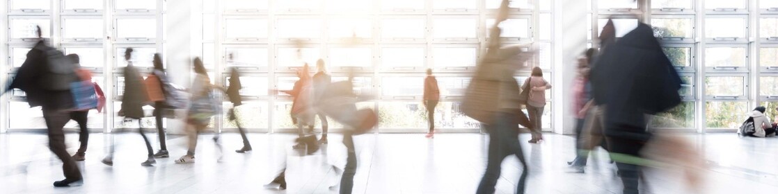 A busy airport terminal with people moving fast and blurring out of focus