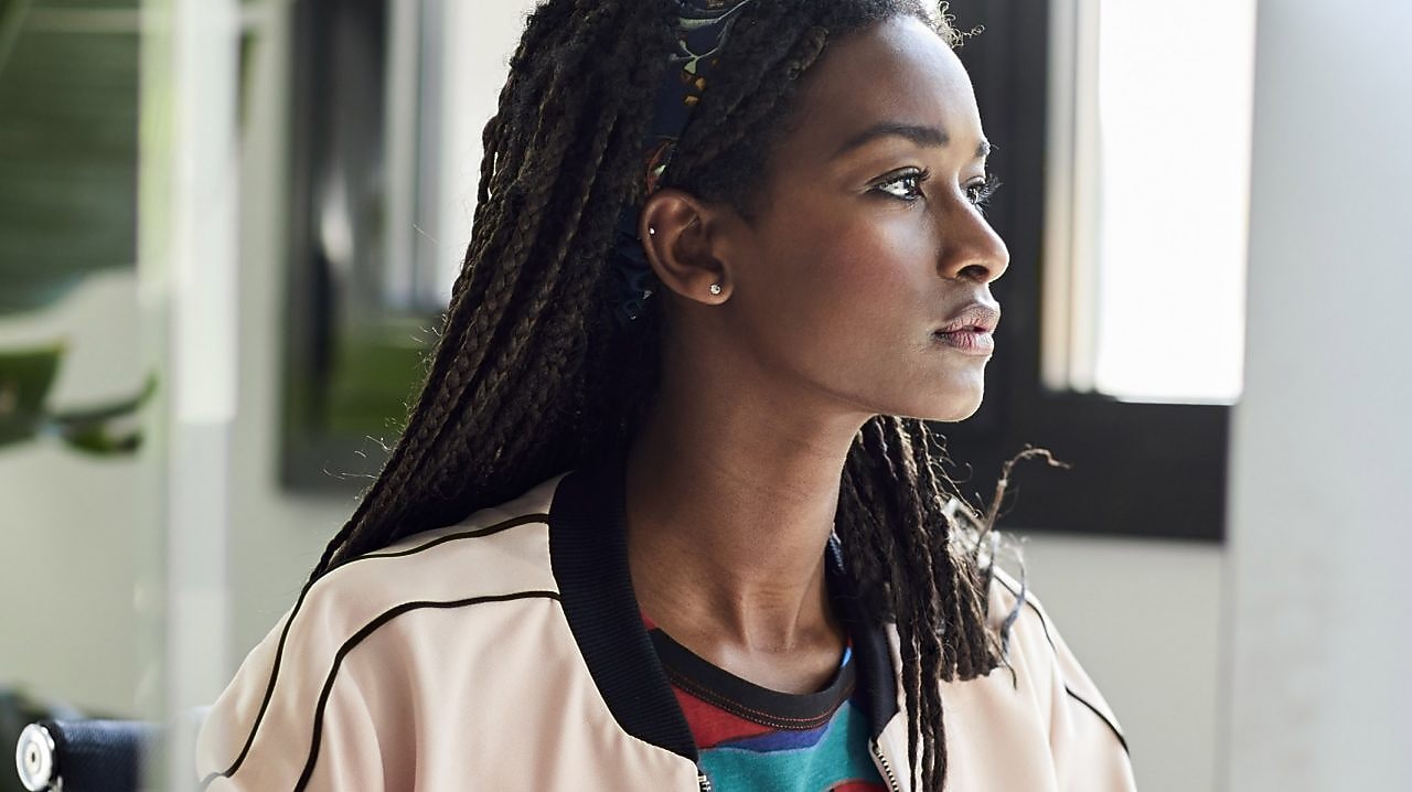 Confident businesswoman using computer at desk by window in creative office