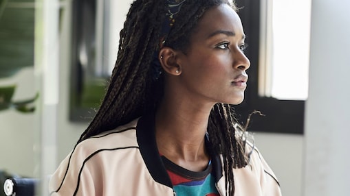 Confident businesswoman using computer at desk by window in creative office