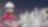 Bearded worker in hard hat, safety glasses, and a red Shell jumpsuit in front of a plant at night.