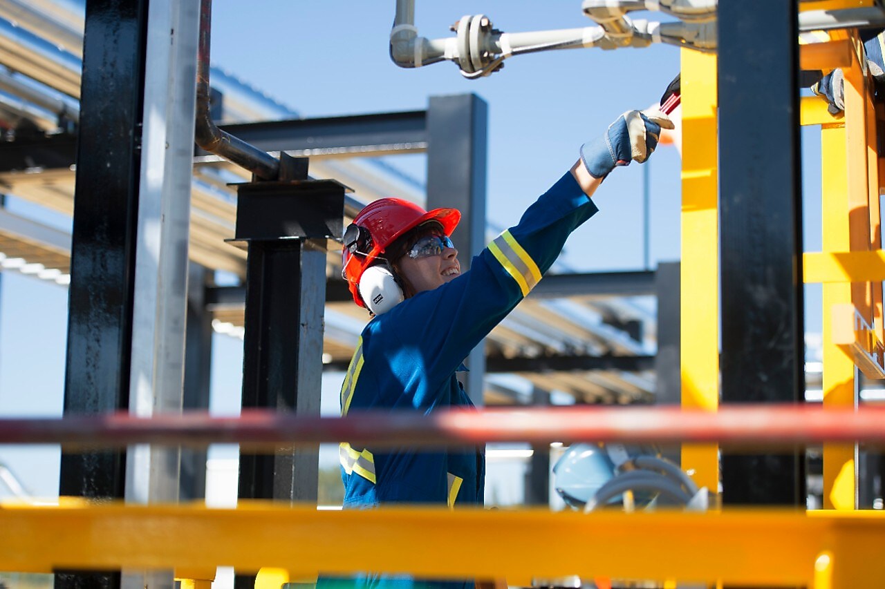 Workers walk toward a drill rig while staving off N2O Abatement