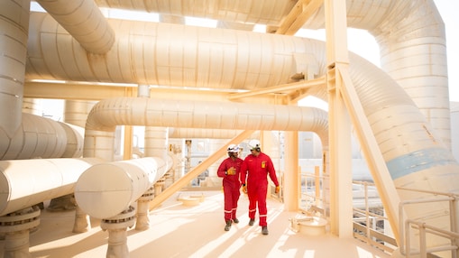 Two workers wearing hard hats walking. Pearl GTL 