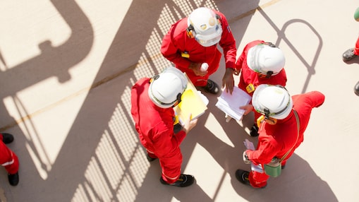 Three employees wearing hard hats discussing at Pearl GTL