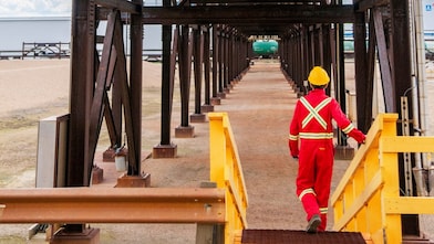 A Shell employee walking toward a reactor with FCC Catalysts.