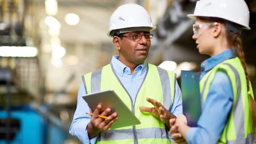 Two engineers discussing work and using tablet