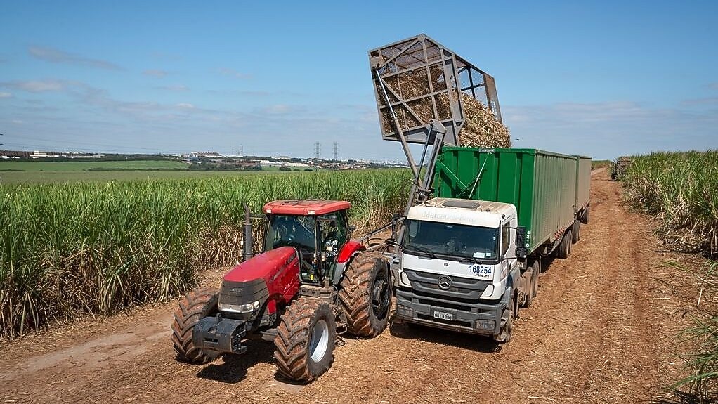 Tractor in agriculture land with truck