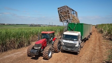 Tractor in agriculture land with truck