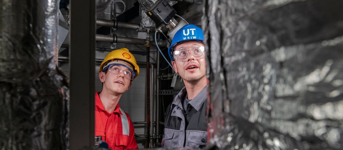 Two colleagues observing CO₂ adsorber inside the pilot plant process container.