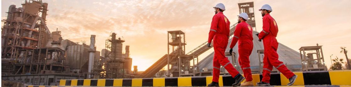 Three employees walking wearing hard hats