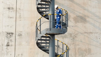 Worker descending the stairs of a LNG tank at hydrocracking facility