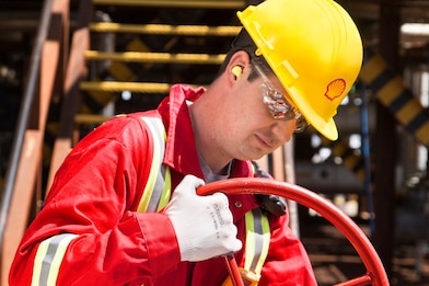 A worker turns a valve used in fluidised catalytic cracking