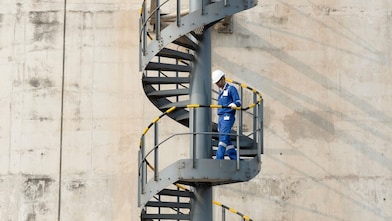 Worker descending the stairs of a LNG tank at hydrocracking facility