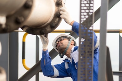 Employee Doing Routine Inspection on a Lng Tan