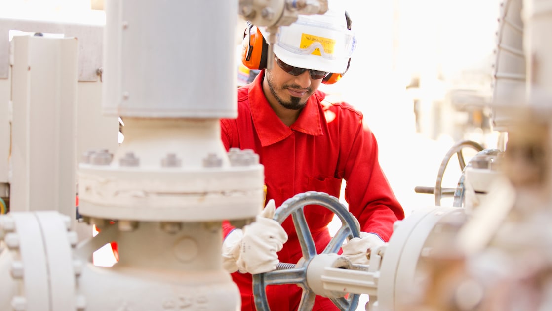 An Area operator in full PPE isolating the valve in preparation to hand over boiler feed water pump to maintenance at Pearl GTL