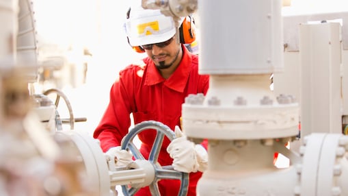 An area operator in full PPE isolating the valve in preparation to hand over boiler feed water pump to maintenance