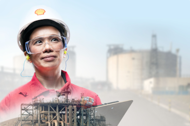 A Shell employee with a refinery in the background