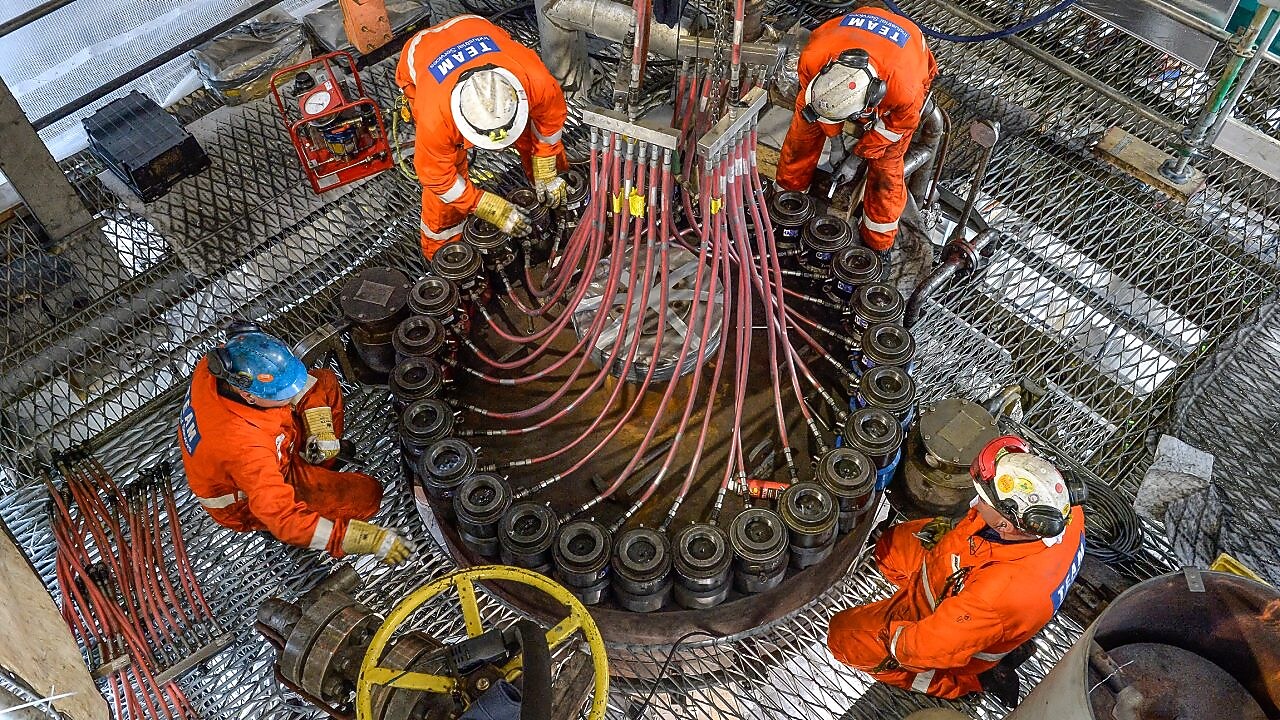 Four engineers working on a pernis refinery machine