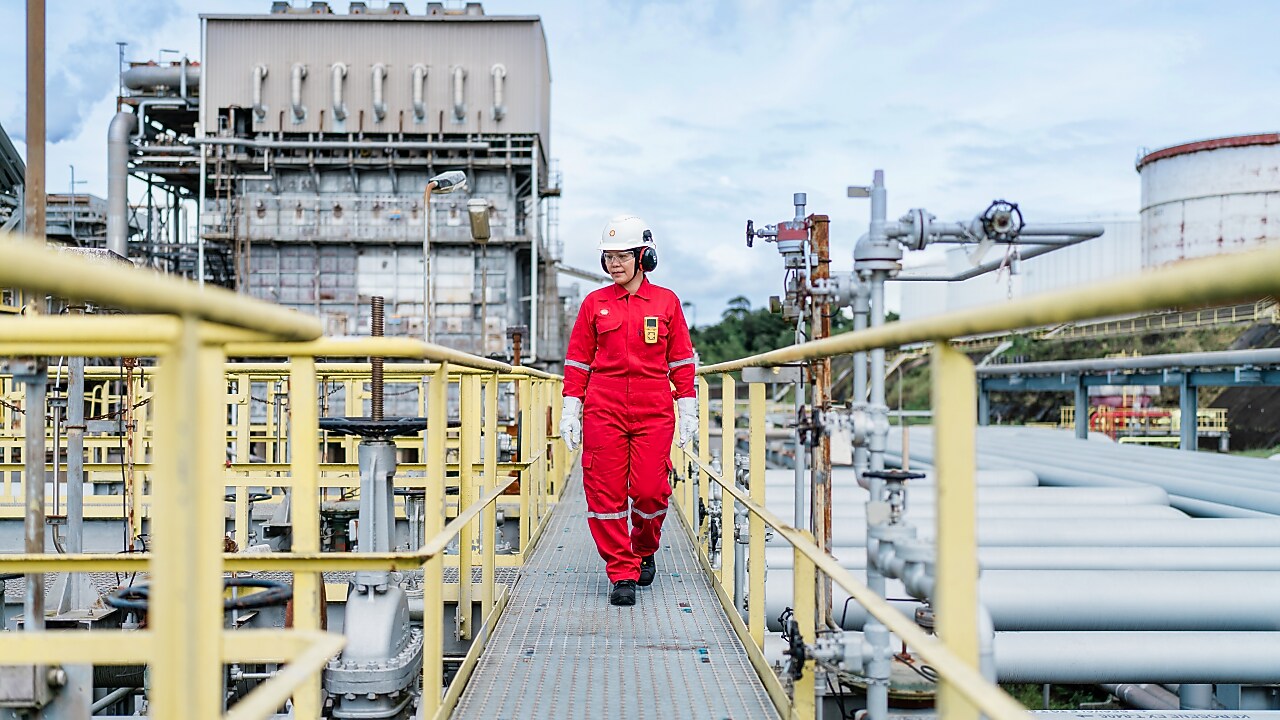 Sell employee walks through refinery during the daytime