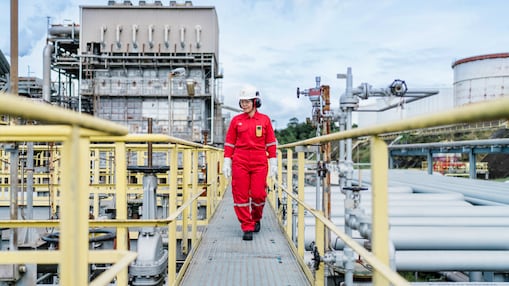 Sell employee walks through refinery during the daytime