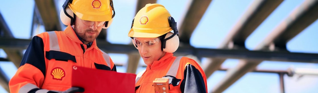 Two employees examining a gauge together