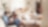 A family is reading a book together on a couch.