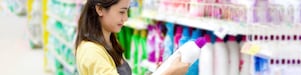 A lady holding detergents in supershop