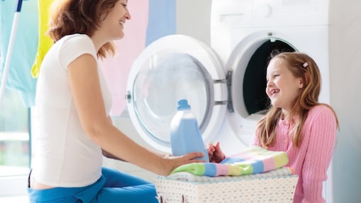 A mom and her daughter doing the laundry.