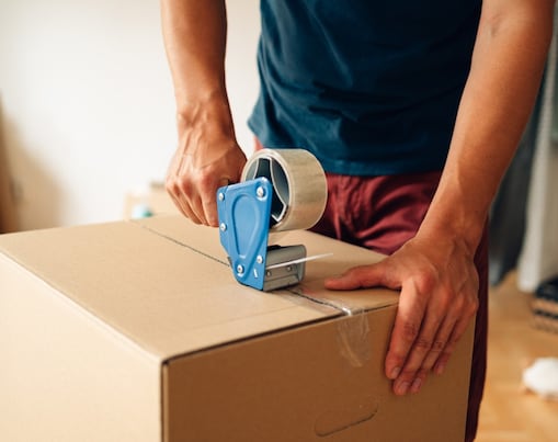 Man using packing tape made sticky with Shell Chemicals