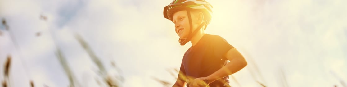 Young boy doing up a cycling helmet