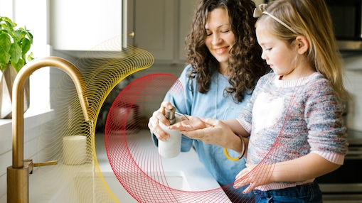 Mother and daughter wash their hands at kitchen sink