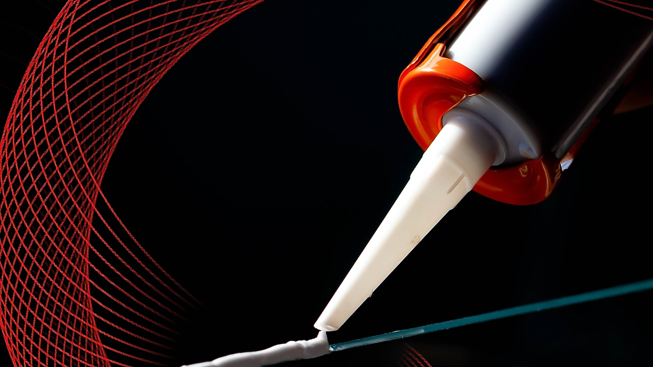 caulking gun applying adhesive to a surface