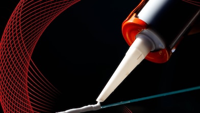 caulking gun applying adhesive to a surface