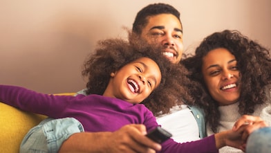 Smiling family sitting on couch