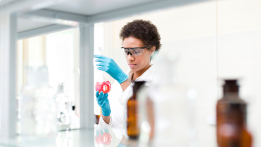 Scientist in a laboratory analyzing liquid in a glass flask
