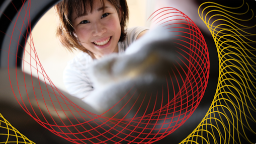 Smiling person loading laundry into a washing machine